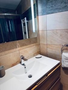 a bathroom with a sink and a mirror at Les Fermes de Cal Panche Le Petit Relais in Les Angles