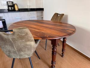 a wooden table and chairs in a kitchen at Les Fermes de Cal Panche Le Petit Relais in Les Angles +4 photos