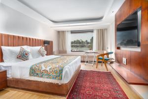 una stanza d'albergo con un letto, un tavolo e una finestra di Hotel 11 Boulevard a Srinagar