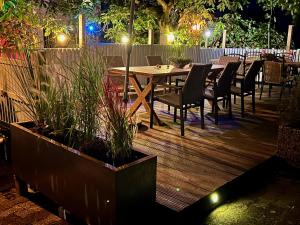 a wooden deck with a table and chairs at night at Ferienweingut Matthias Löwen in Detzem