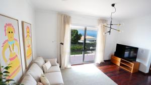 a living room with a couch and a television at NostraCasa by LovelyStay in Caniço
