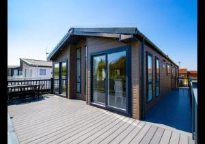 a small house on a deck with glass windows at MP778 - 2B Lodge - Parkdean - Camber Sands in Camber