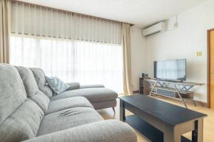 a living room with a couch and a flat screen tv at Nikko Toyama Forest House in Nikko