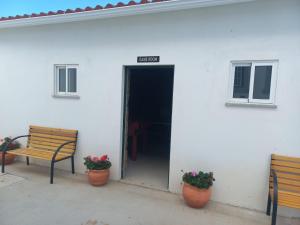 a white building with two benches and a door at Casa de Cardigos in Cardigos
