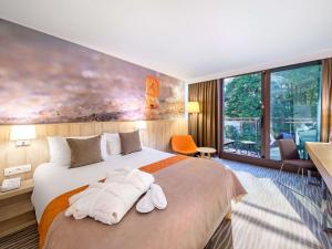 a hotel room with a bed with towels on it at Mercure Gdańsk Posejdon in Gdańsk