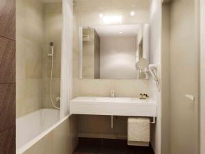 a bathroom with a white sink and a shower at Mercure Gdańsk Posejdon in Gdańsk