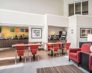 a restaurant with red chairs and tables in a room at Clarion Pointe in Campbellton