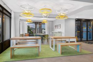 科罗拉多斯普林斯Spark by Hilton Colorado Springs I 25 Central的有桌椅和吊灯的餐厅