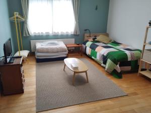 a bedroom with a bed and a table and a couch at Casa YuriMomo in Date