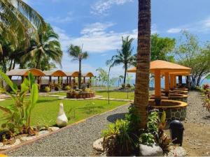 a resort with tables and gazebos and palm trees at Anelasplace Beach Resort in Bansud
