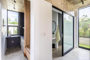 a bathroom with a sink and large windows at SALT Luxury Guest Suite Plett in Plettenberg Bay
