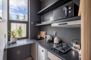 a kitchen with a stove top oven next to a window at SALT Luxury Guest Suite Plett in Plettenberg Bay