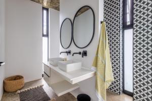 a bathroom with a sink and a mirror at SALT Luxury Guest Suite Plett in Plettenberg Bay