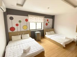 a bedroom with two beds and a wall with colorful dots at Jolilian Homestay Vũng Tàu in Vung Tau