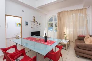 a living room with a glass table and red chairs at 2 bedroom apartment with Sea view in Trstenik