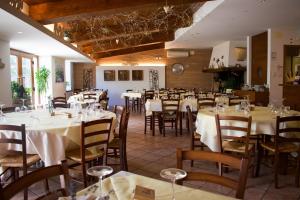 a restaurant with tables and chairs with white tablecloths at Agriturismo Monte Del Re in San Pietro al Natisone