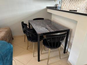 Una mesa negra con sillas negras al lado de un mostrador. en Duplex cornish lac2, en Túnez 5 fotos más
