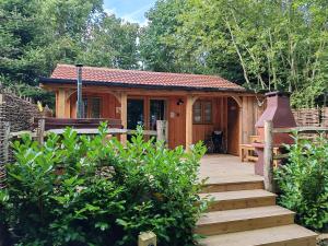 a small cabin with a wooden walkway leading to it at Hayne Barn Estate - Luxury Lodges with private hot-tubs- The studio-loft is without hot-tub in Hythe