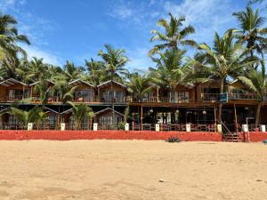 a resort on the beach with palm trees at Jardim a Mar in Agonda