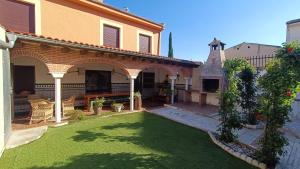 a courtyard of a house with a green lawn at Casa Alda in Cabezuela
