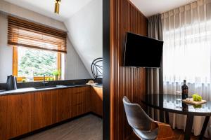 Televízia a/alebo spoločenská miestnosť v ubytovaní Apartamenty Chramcówki 7
