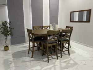 a wooden dining room table and chairs on a tile floor at D Raihan Guest House in Ketereh