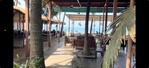 a restaurant with tables and chairs on the beach at Jardim a Mar in Agonda