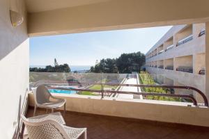 een balkon met stoelen en uitzicht op een zwembad bij Four Points by Sheraton Sesimbra in Sesimbra