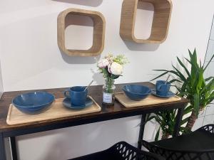 Una mesa con cuencos azules y flores encima. en Studio centre ville moderne, en Le Havre 14 fotos más