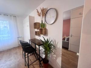 un comedor con una mesa y un reloj en la pared en Studio centre ville moderne, en Le Havre