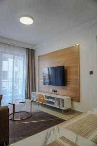 a living room with a flat screen tv on a wall at Ruaka apartment with a swimming pool in Nairobi