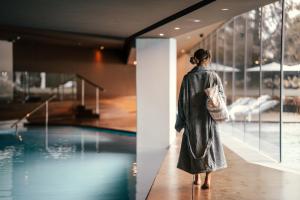 a woman in a dress standing next to a pool at Lido Palace - The Leading Hotels of the World in Riva del Garda