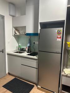 a small kitchen with a refrigerator and a sink at Riveria City KL Sentral in Kuala Lumpur