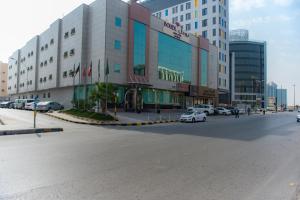 eine Stadtstraße mit Autos, die vor den Gebäuden geparkt sind in der Unterkunft Boudl Khurais in Riad