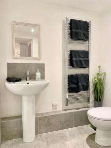 a white bathroom with a sink and a toilet at Modern, period property with Parking - Located near Uni, Hospital & Town Centre in Reading