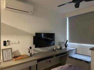 a room with a desk with a tv on a wall at Riveria City KL Sentral in Kuala Lumpur