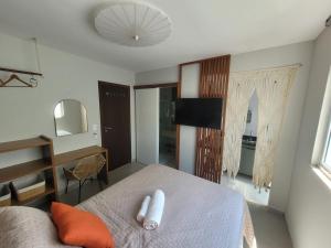 a bedroom with a bed and a desk and a mirror at Apartamento Boho Style Absolute piscina borda com borda infinita in Morro de São Paulo
