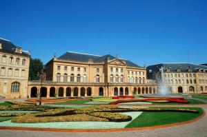 a large building with a fountain in front of it at PRESTIGE HOME Metz GARE in Metz