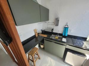 a small kitchen with a black counter top at Apartamento Boho Style Absolute piscina borda com borda infinita in Morro de São Paulo
