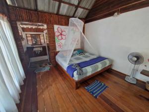 a bedroom with a bed with a mosquito net at Angthong Beach Resort in Koh Phaluai