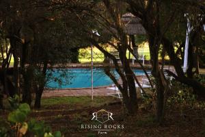 una piscina en un patio con árboles en Refreshing Mountain FarmStay w Boma,Pool,Hikes,Obstacle Course, en Magaliesburg