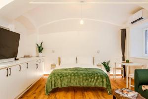 a bedroom with a bed with a green blanket at Sofija's Central Apartments in Ljubljana