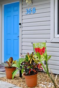 a house with a blue door and some plants at Beach House Retreat in Cape Canaveral