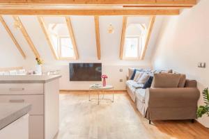 a living room with a couch and a tv at Sofija's Central Apartments in Ljubljana