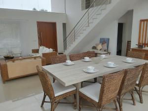 ein Esstisch und Stühle in einem Wohnzimmer in der Unterkunft Casa de Verão no Condomínio Porto Coronado in Xangri-lá + 6 Fotos
