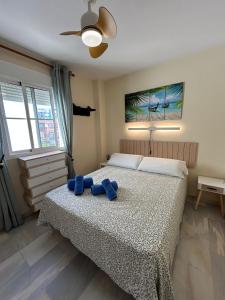 a bedroom with a bed with blue towels on it at HOLIDAYS & HOME II, 3 habitaciones, piscinas ,150 metros playa in Benalmádena