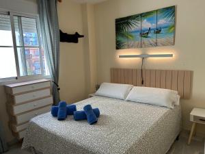 a bedroom with a bed with a blue toy on it at HOLIDAYS & HOME II, 3 habitaciones, piscinas ,150 metros playa in Benalmádena +35 photos