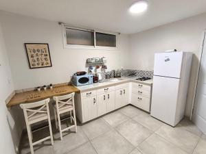 a kitchen with a refrigerator and a counter with stools at Michael's- A Lovely Studio Apartment in Eilat