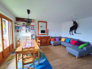 a living room with a blue couch and a cat on the wall at Le Chamois d'Assy, résidence alpine de charme in Passy
