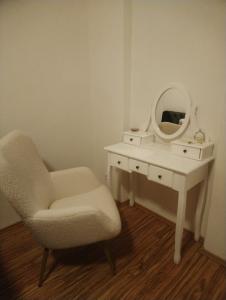 a bedroom with a chair and a dressing table with a mirror at Luxusní byt v centru - Free Parking in Karlovy Vary
